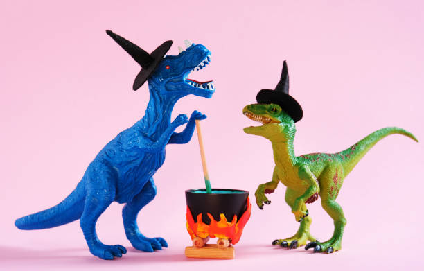 istock Green and blue dinosaur brewing potion on pink background. 1646649701