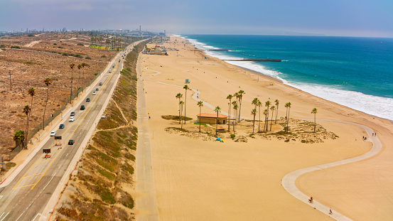 Aerial view of cars driving on coastal road by Playa Del Rey beach, Los Angeles, California, USA.