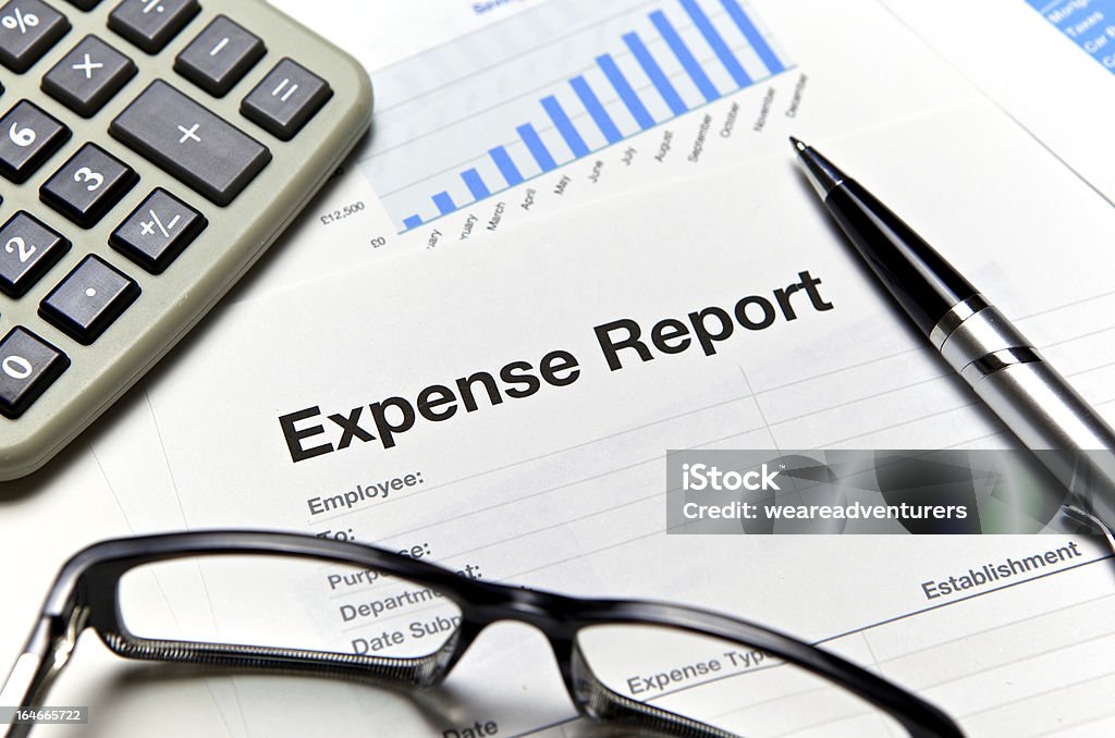 Close-up of an expense report with glasses and a calculator Close up of an expense form with calculator and pen. Expense Stock Photo