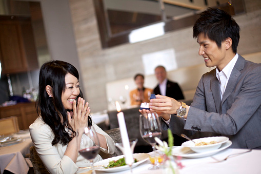 Young Japanese male proposing to his partner over dinner. 