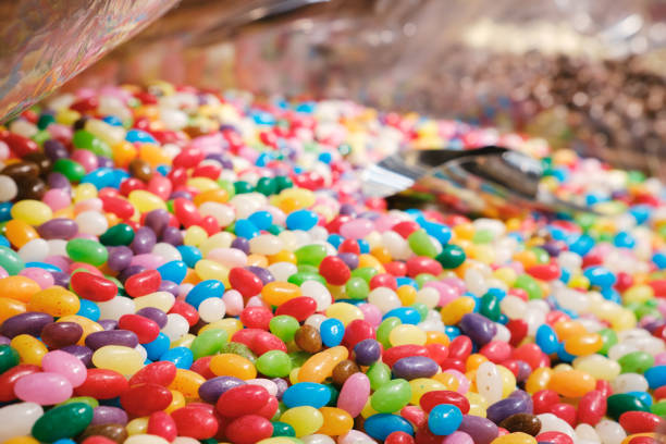 istock Mixed multi-colored jelly beans and a metal scoop in a candy store. 1646658571