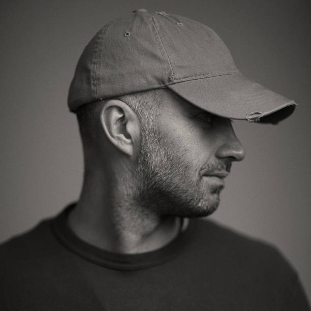 Handsome men Black and white portrait of handsome men, studio shot, vintage look and strong grain added to create atmosphere. sideways baseball hat stock pictures, royalty-free photos & images