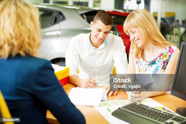 Alegre Casal Jovem Comprar Carro - Fotografias de stock e mais imagens de Stand de Carros - Stand de Carros, Carro, Secretária - Mobília