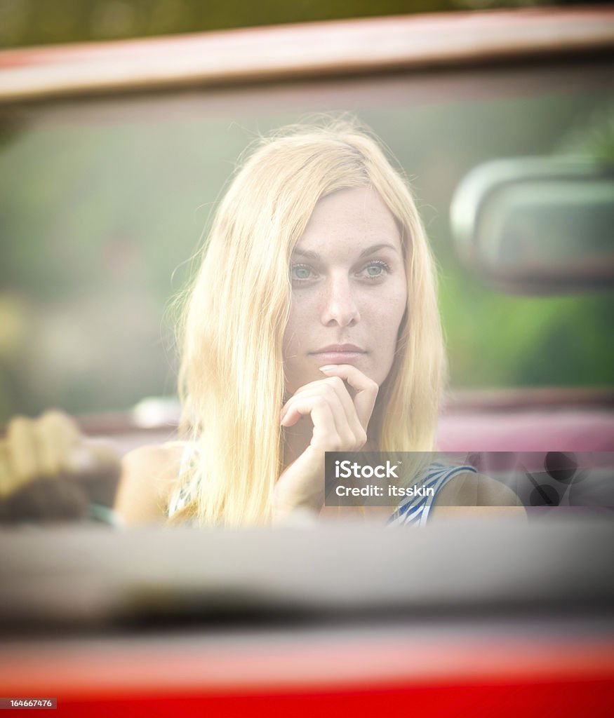 Rubia mujer mirando en un espejo retrovisor - Foto de stock de 20 a 29 años libre de derechos