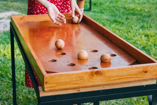 istock Wooden Pastimes: Amidst a summer backdrop, hands engage in a fun board game, embracing outdoor leisure and cultural enjoyment. 1646678721