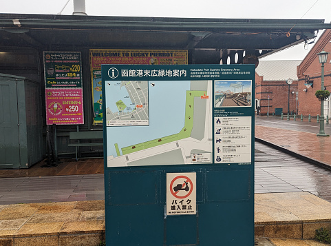 Hakodate, Japan - June 10, 2023: A map posted by Hakodate Bay shows the Hakodate Port Suehiro Greenery Area in the redeveloped warehouse district. Spring morning in the rain in Hokkaido Prefecture.
