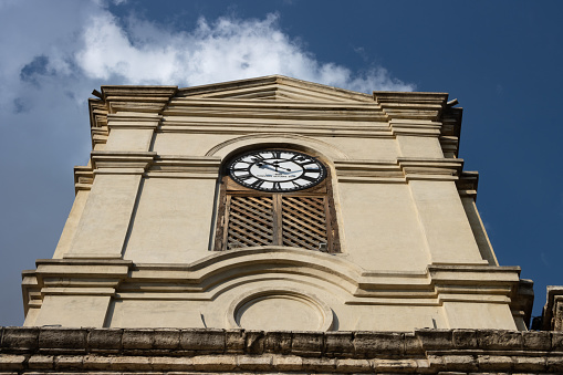 Church tower with analog clock, blue sky background