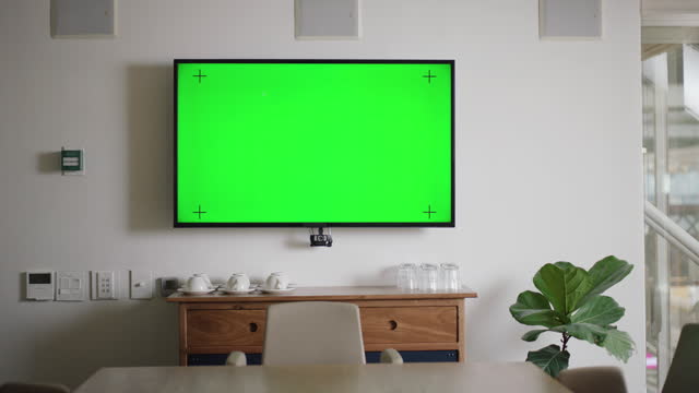 Empty office, green screen and television in company, workplace or boardroom on mockup space. Tv, workspace or corporate room with tracking markers, table or furniture on business interior background