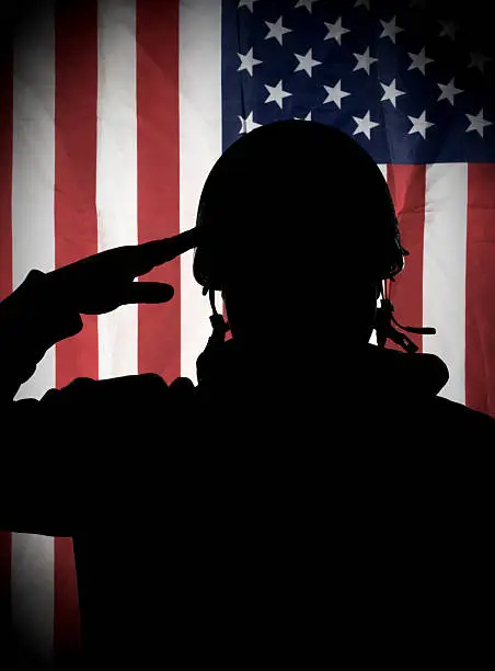 Photo of American (USA) soldier saluting to USA flag