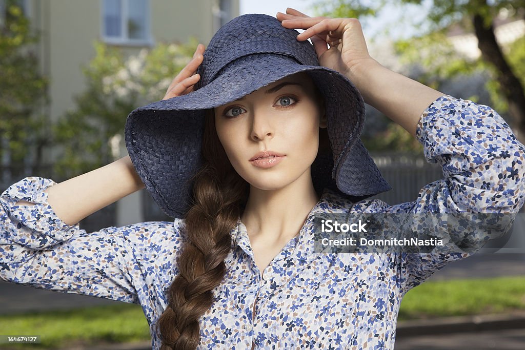 Przestraszona Dziewczyna Trzymając jej kapelusz z rękami - Zbiór zdjęć royalty-free (Adolescencja)