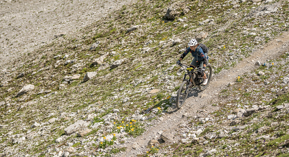 Female mountain bike descending a mountainbike trail in Arosa, Switserland. Frontview. Summer, day. Copy space is available.