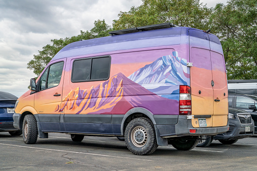 Loveland, CO, USA - August 25, 2023: Mercedes Sprinter camper van with a colorful mountain theme graphics.
