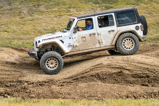 Loveland, CO, USA - August 26, 2023: Jeep Wrangler, Rubicon model, on a muddy and bumpy training drive off-road course.