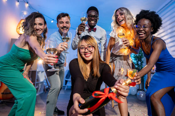 istock Group of multiracial people having fun during house party while toasting with champagne 1646783373