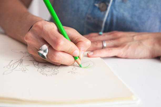 istock Close-up of the illustrator's hands colouring her work. 1646797091