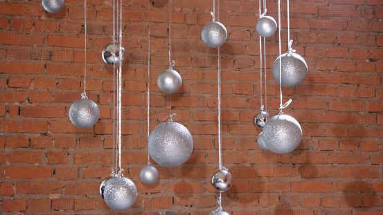 Silver Christmas balls on the background of a wall of red brick loft