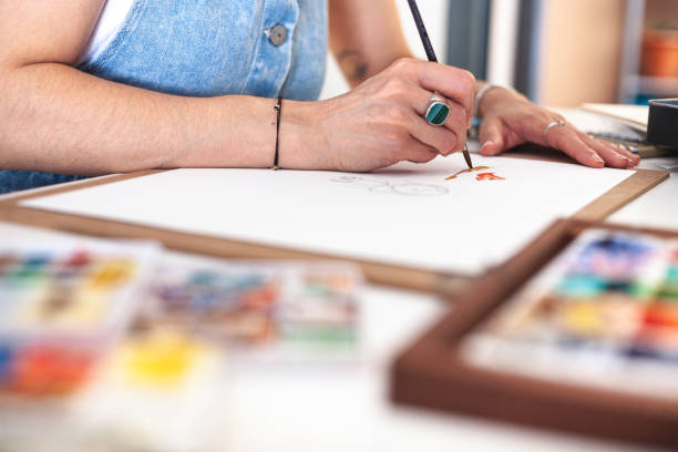 istock Selective focus on the hands of an illustrator painting her work among the different watercolour materials. 1646823207