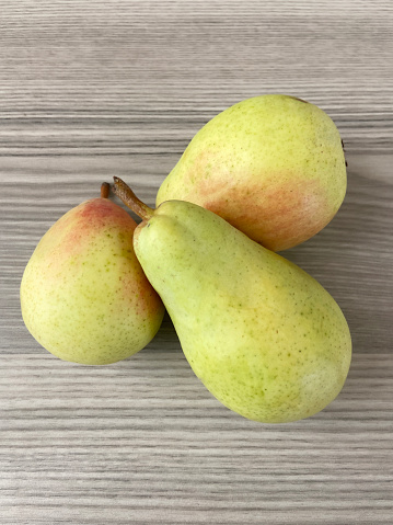 Directly above three fresh pears on the wood background
