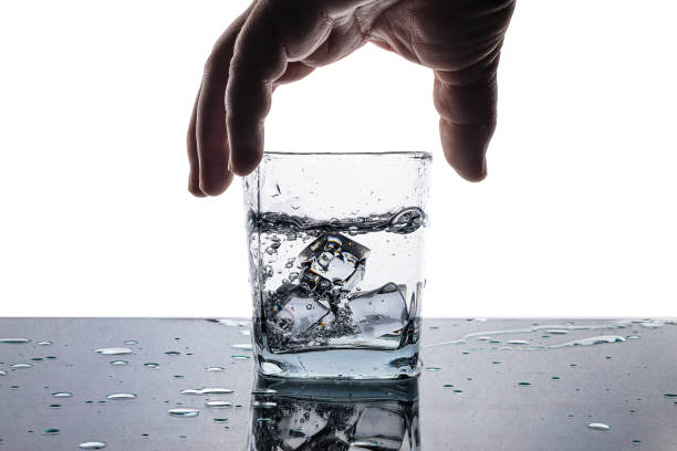 Human hand and a glass of ice water