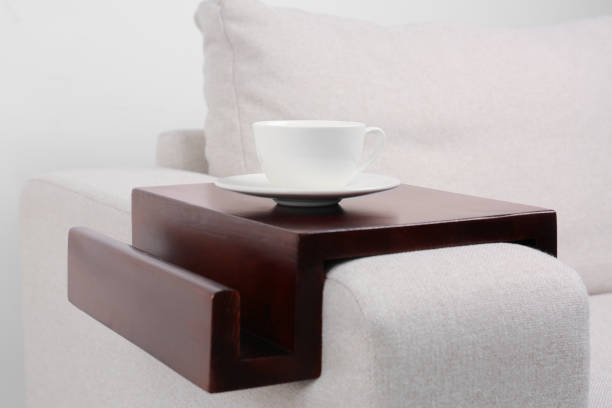 istock Cup of coffee on sofa with wooden armrest table indoors. Interior element 1646846576