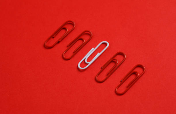istock Red and white paper clips on red background. Creative layout. Business concept. Exclusivity, uniqueness. Do not be like everyone else 1646846988