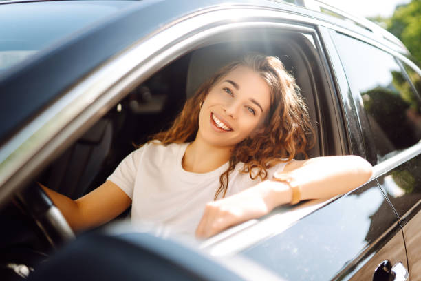 istock Smiling woman driving a car. 1646852361