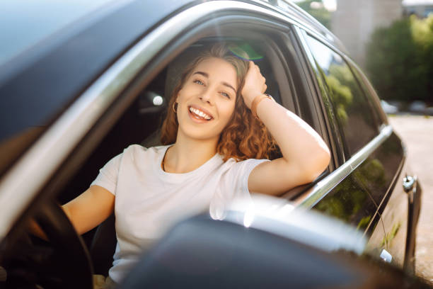 istock Smiling woman driving a car. 1646852362