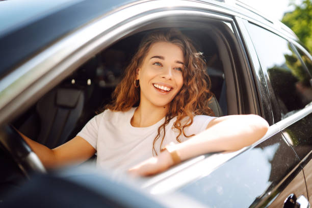 istock Smiling woman driving a car. 1646852363