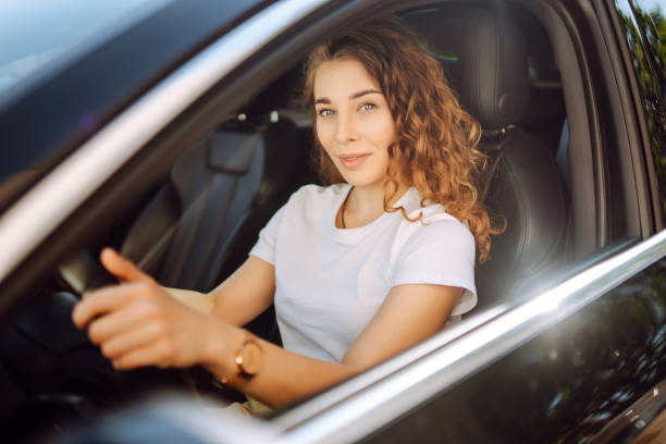 istock Smiling woman driving a car. 1646852483