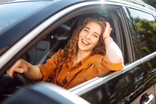 istock Smiling woman driving a car. 1646852881