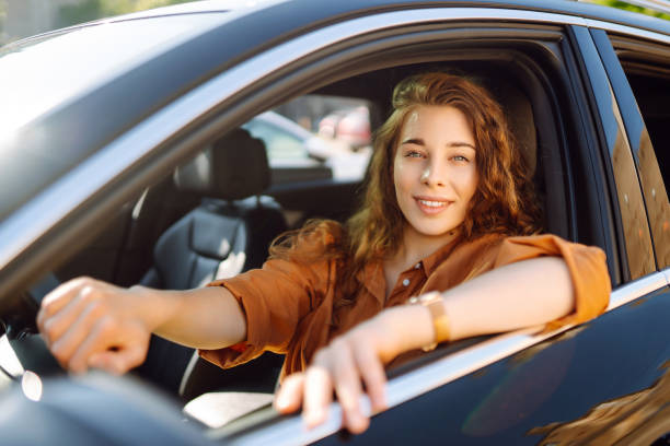 istock Smiling woman driving a car. 1646852891