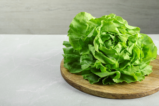 Fresh green butter lettuce on light table, space for text
