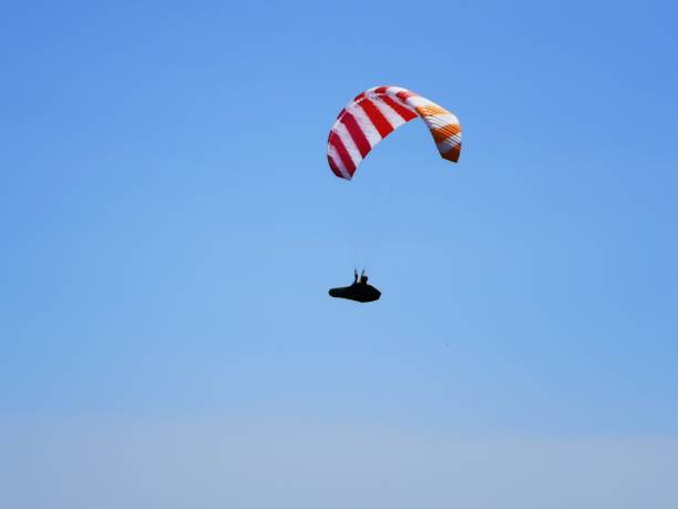 istock A paraglider soars high through the blue sky. 1646878161