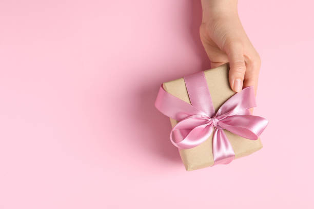 istock Woman with gift box on pink background, top view. Space for text 1646886147