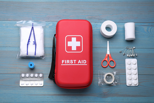Flat lay composition with first aid kit on blue wooden table