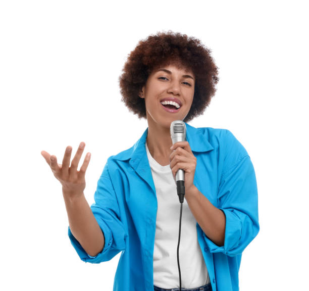 istock Curly young woman with microphone singing on white background 1646943172