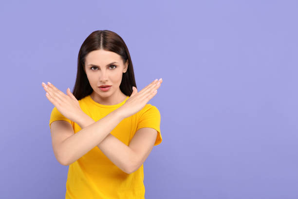 istock Stop gesture. Woman with crossed hands on violet background, space for text 1646945359