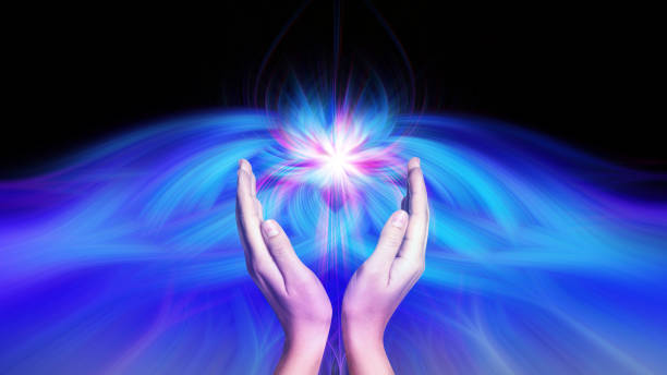 istock Aura phenomena. Woman with flows of energy making beautiful pattern between her hands against black background, closeup 1646961327