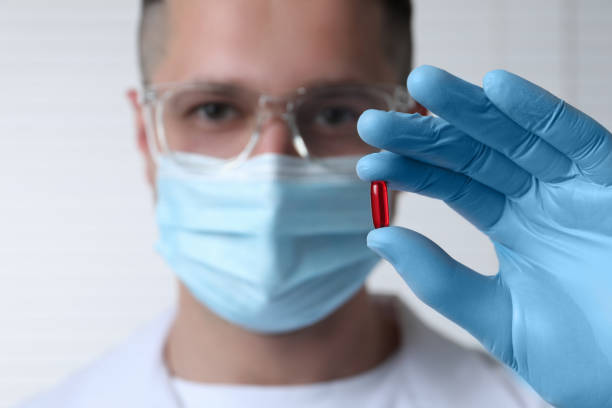 istock Doctor holding pill on light background, selective focus. Space for text 1646984273