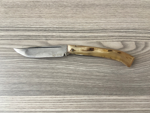 Directly above a knife weapon on wood background