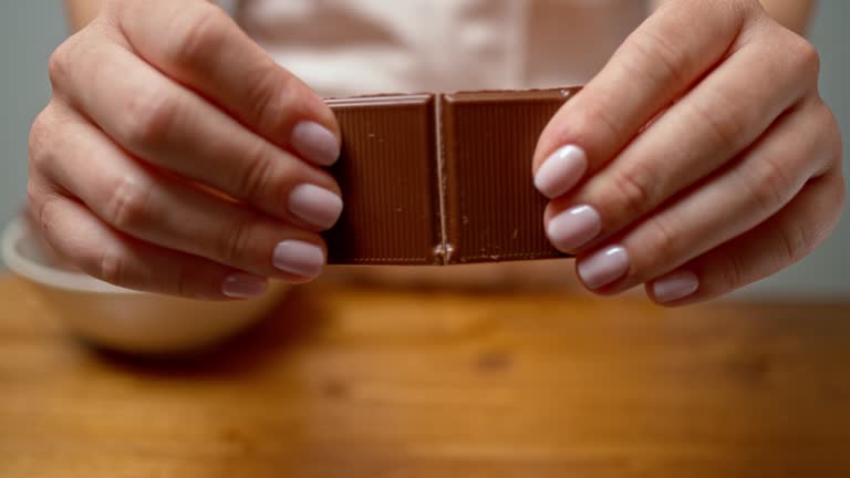 SLO MO LD Female hands breaking a chocolate