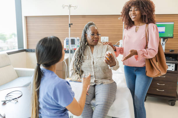istock Nurse and patient's daughter talk while mom looks at medication 1646996239