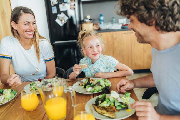 istock Happy young family eating together 1647014401