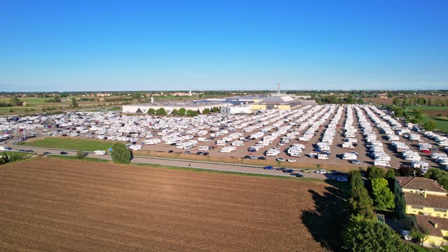 Motorhomes and campingcars in parking lot view from above at auto in annual exhibition of camper vans (Salone del Camper). Best option for travel feeling free. Parma, Italy - September 17, 2022. 4K