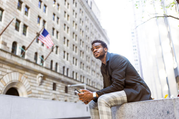 istock Businessman using phone in Wall Street area 1647068302
