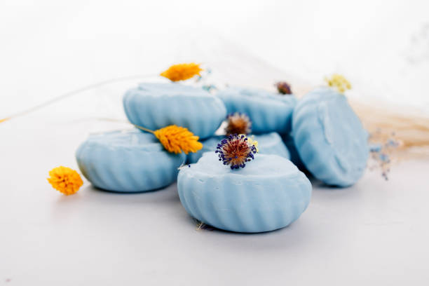 Handmade light blue soap with flowers on fabric, close-up