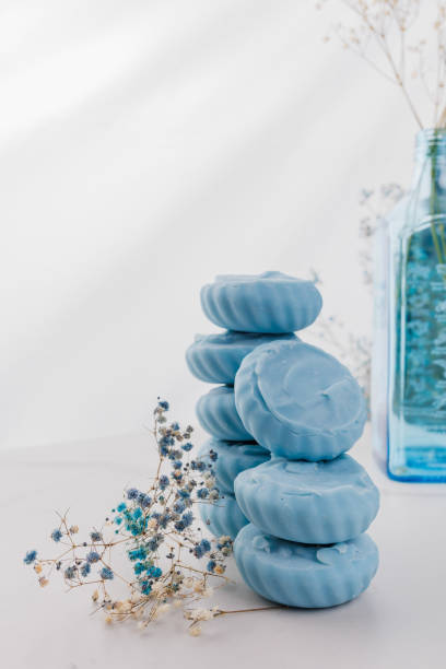 istock Handmade light blue soap with flowers on fabric, close-up. 1647086934