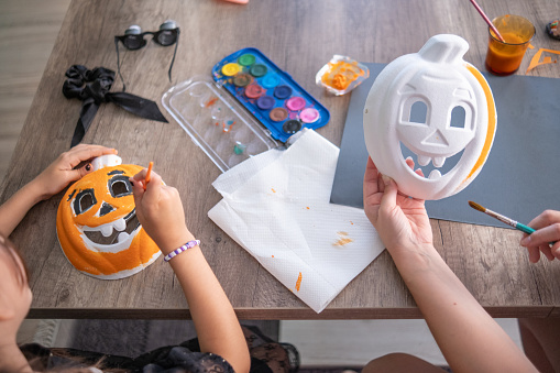 Sisters painting a Pumpkin mask for their upcoming party