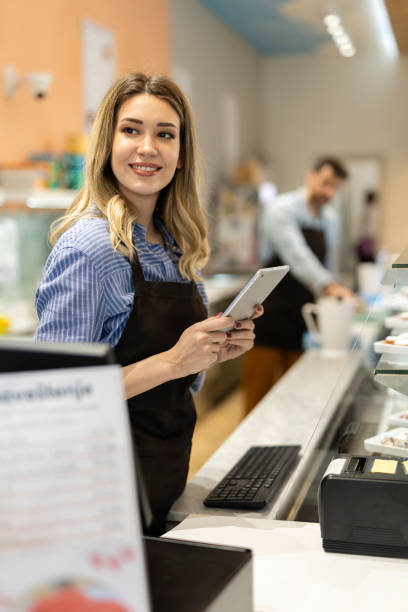 Smiling young baker at the checkout counter.
