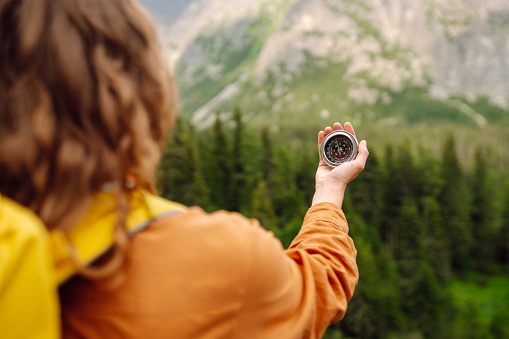 Rear view of an active senior man taking a photo with his cell phone of Crater Lake while on a hike on a warm and sunny summer day in Oregon.